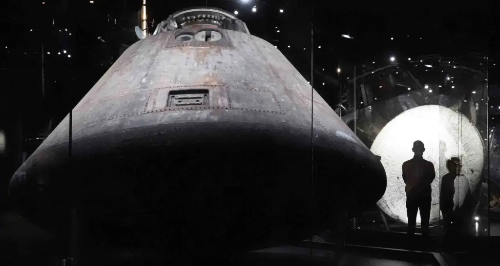 A visitor stands by the moon next to a historical...