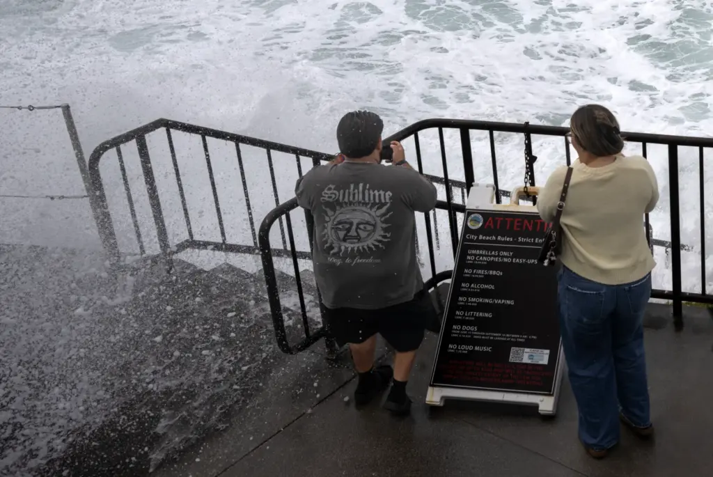 Waves crash onto a viewing deck at Brooks Street Beach...