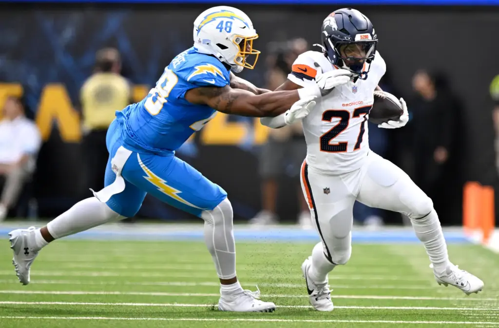 Denver running back J.K. Dobbins (27) finds room to run...