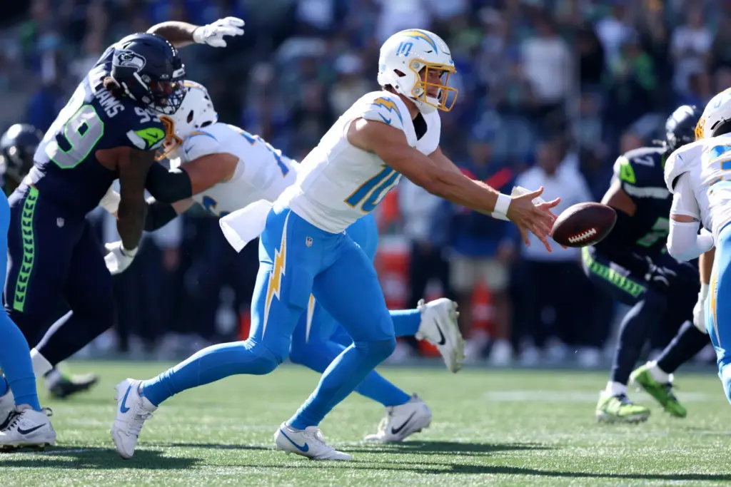 Chargers quarterback Justin Herbert (10) pitches the ball during the...