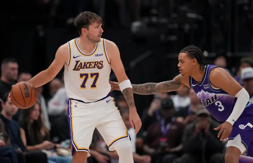 Lakers forward/guard Luka DonÄiÄ (77) dribbles as he is defended...