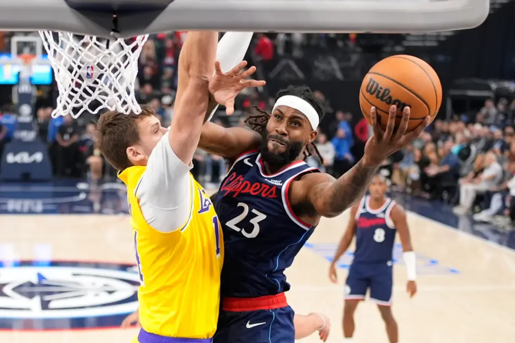 Clippers forward/center Isaiah Jackson, right, shoots as Lakers center Walker...