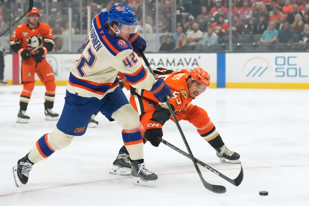 Edmonton Oilers right wing Kasperi Kapanen, left, passes the puck...