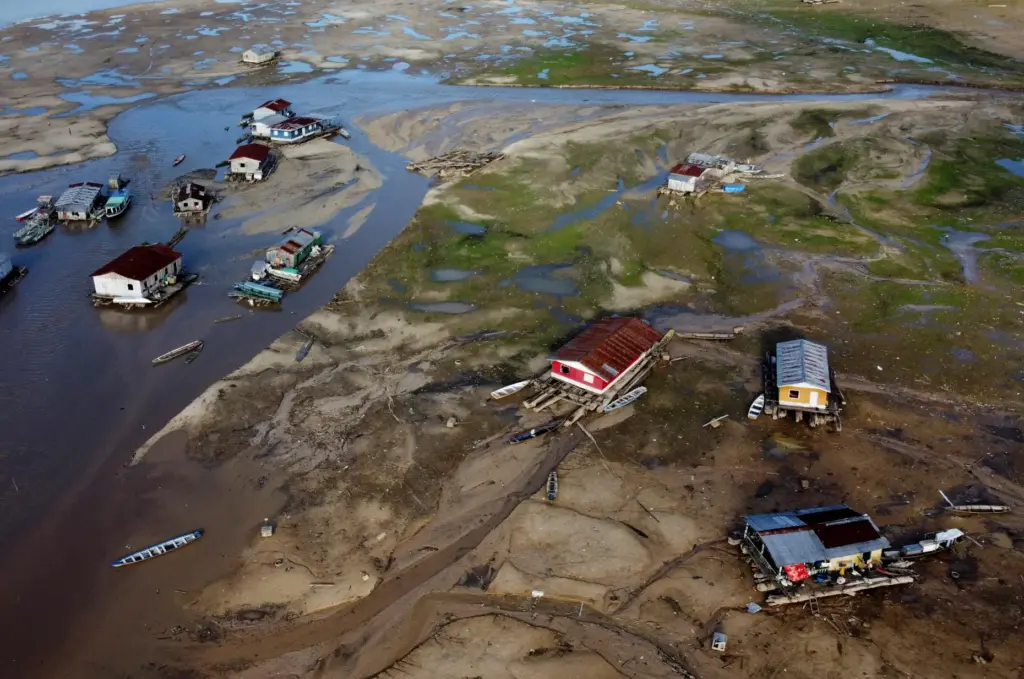 FILE – Houseboats sit amid drought-impacted land near the Solimões...