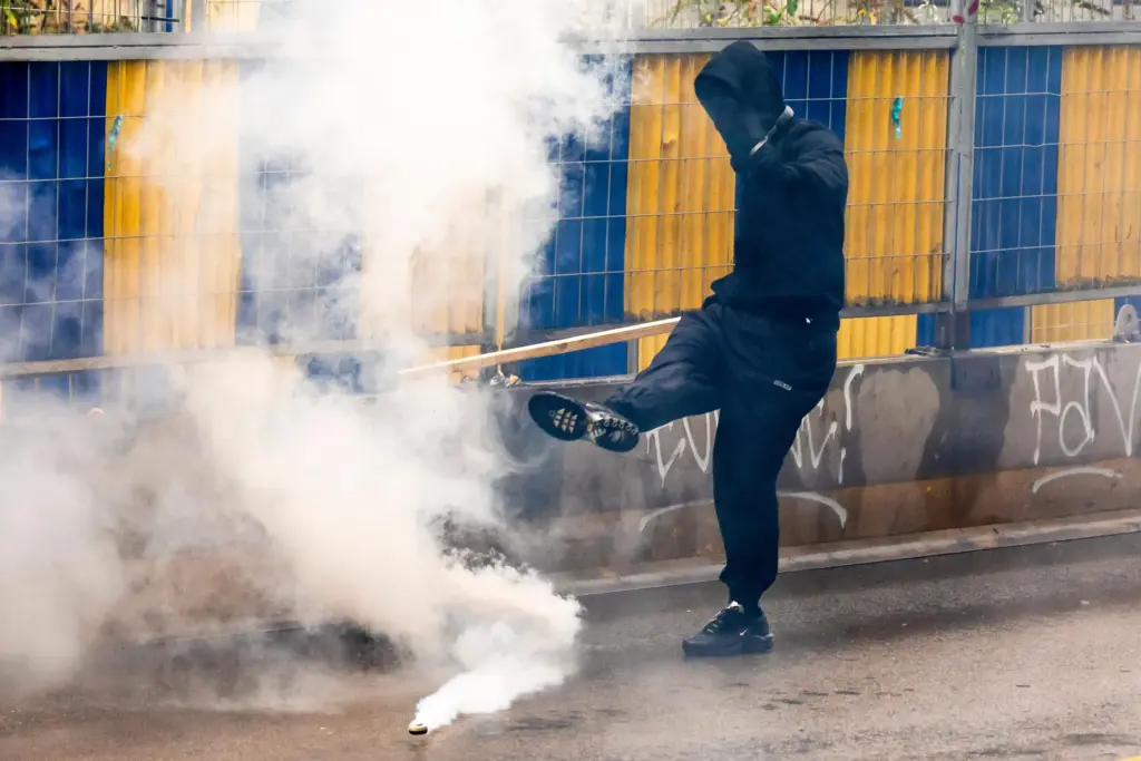 A man kicks a tear gas canister back toward police during a national protest in Brussels.
