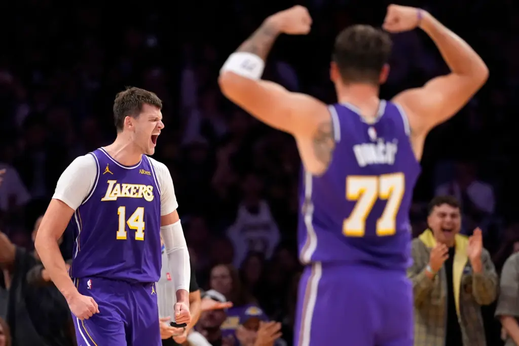 Lakers center Walker Kessler, left, celebrates along with guard Luka...
