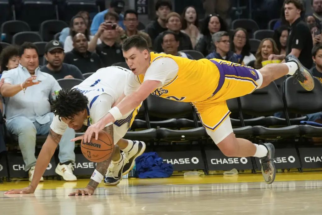 Lakers forward Jake LaRavia, right, dives for the ball next...