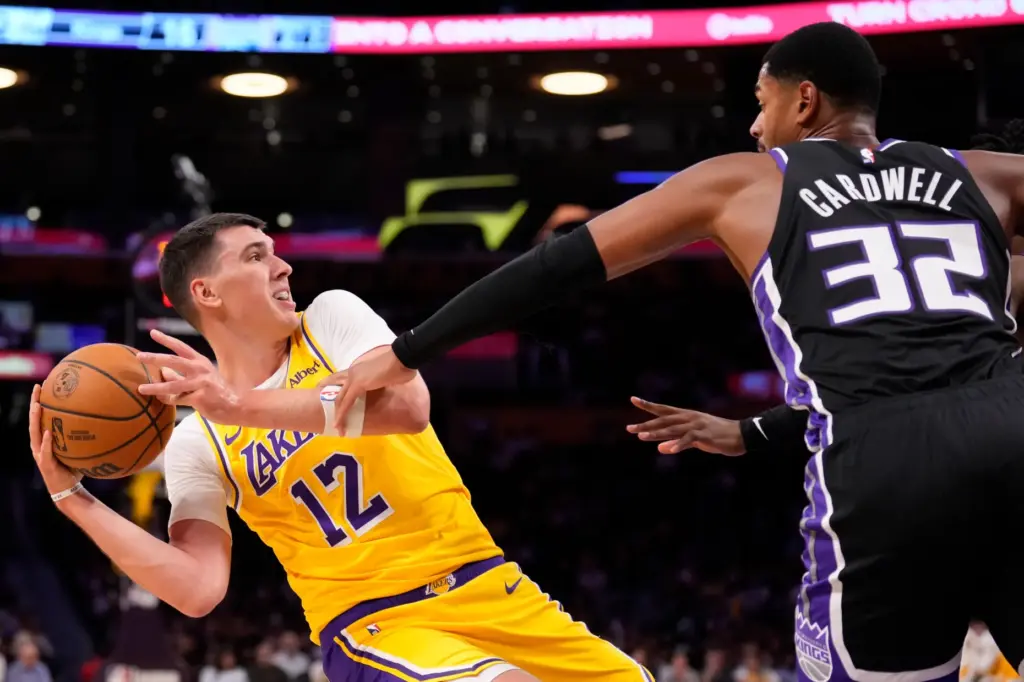 Lakers forward Jake LaRavia, left, tries to pass the ball...