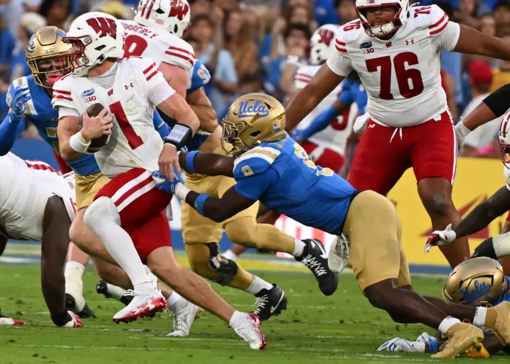 Linebacker Jalen Woods #9 of the UCLA Bruins chases quarterback...
