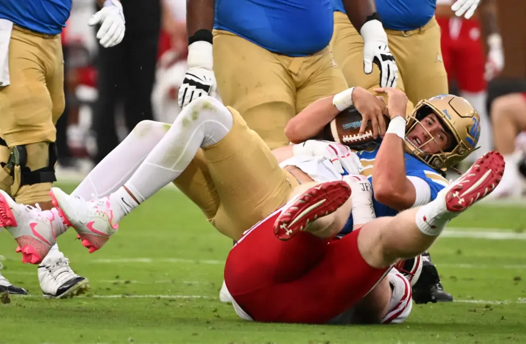 Quarterback Ty Dieffenbach #14 of the UCLA Bruins is tackled...
