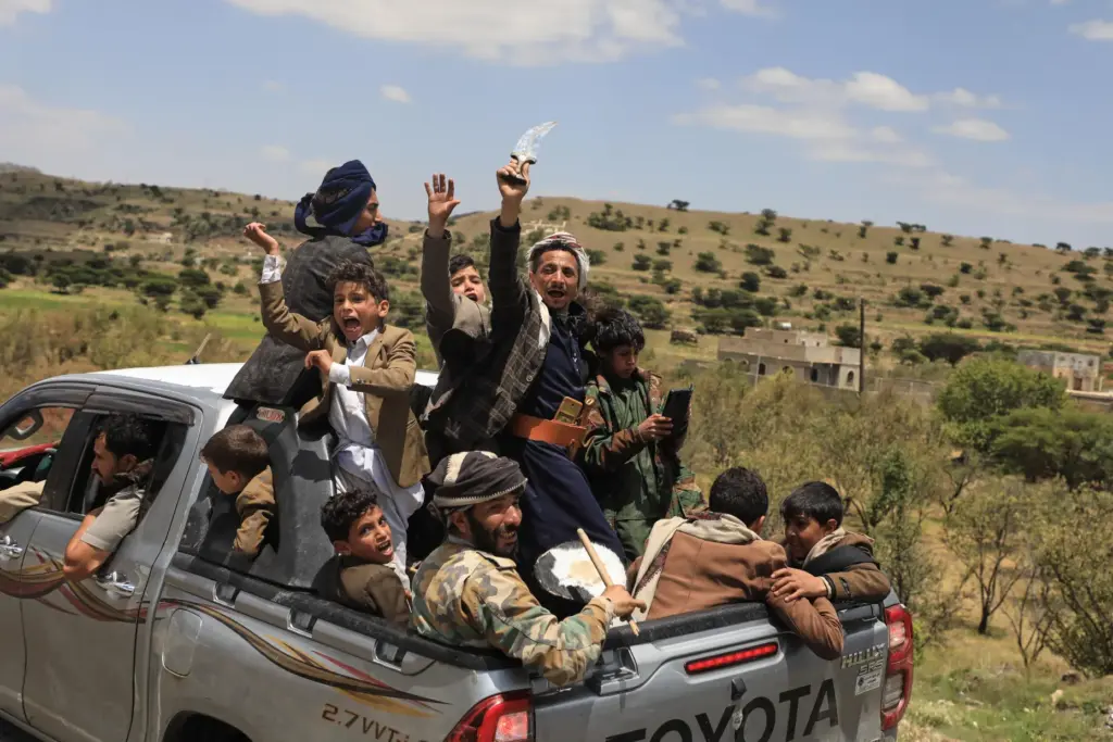 Yemeni civilians celebrate while riding in the back of a...