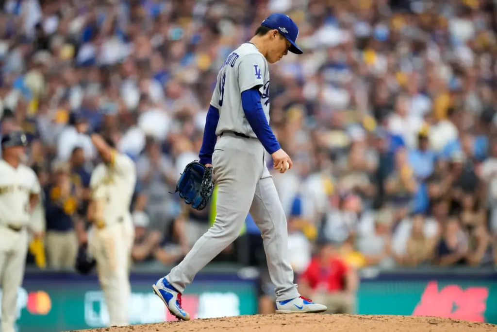 Dodgers starting pitcher Yoshinobu Yamamoto walks on the mound after...