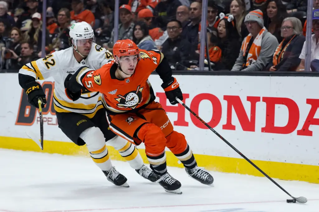Ducks right wing Beckett Sennecke, right, skates against Boston Bruins...