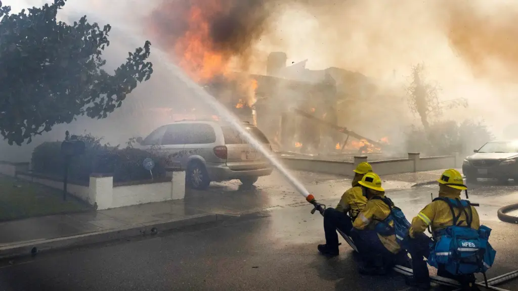 Firefighters work to save structures on Via La Mirada during...