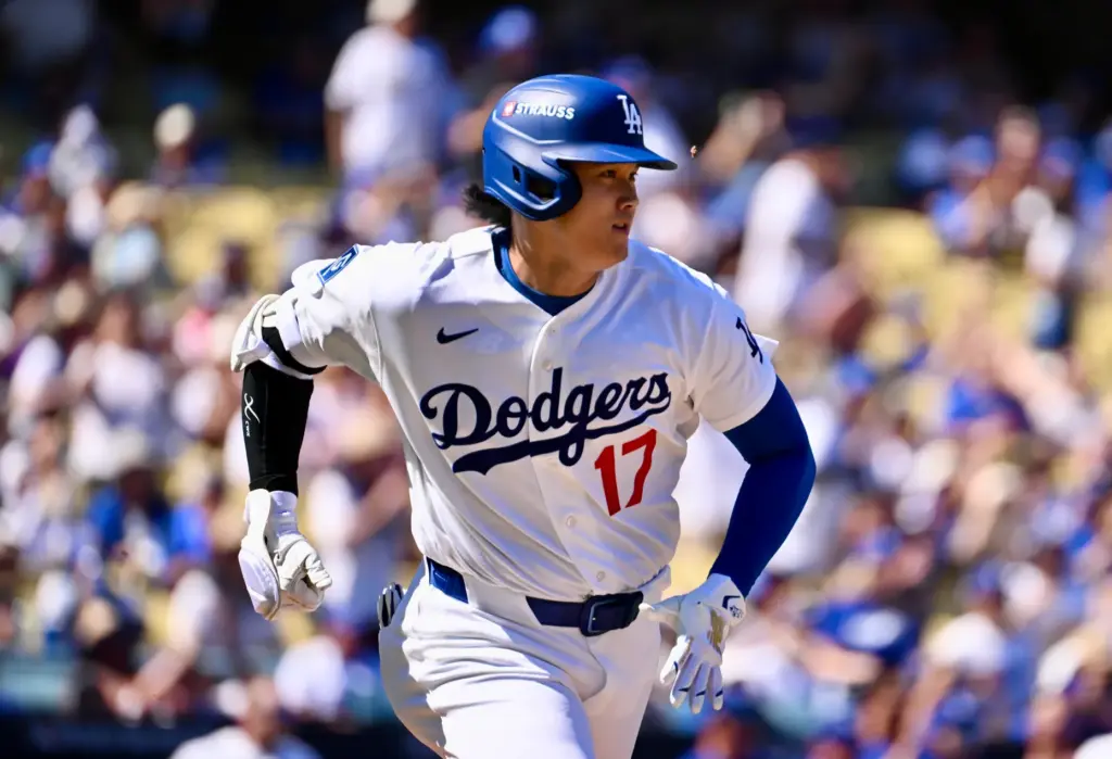 Dodgers star Shohei Ohtani runs to first base after hitting...