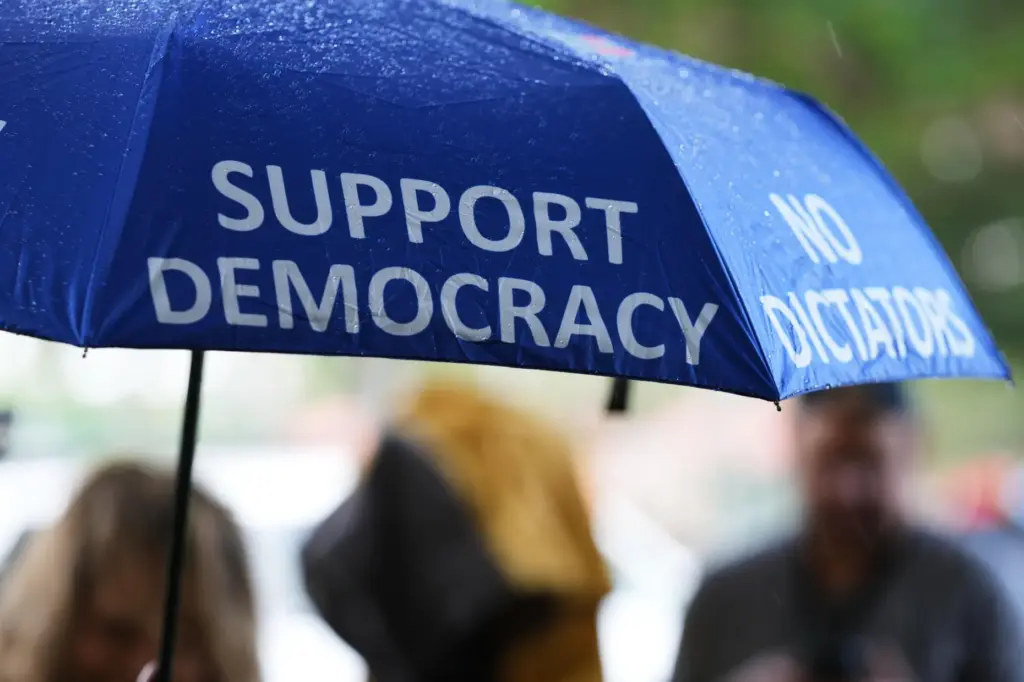 A person carries an umbrella outside a polling location during...