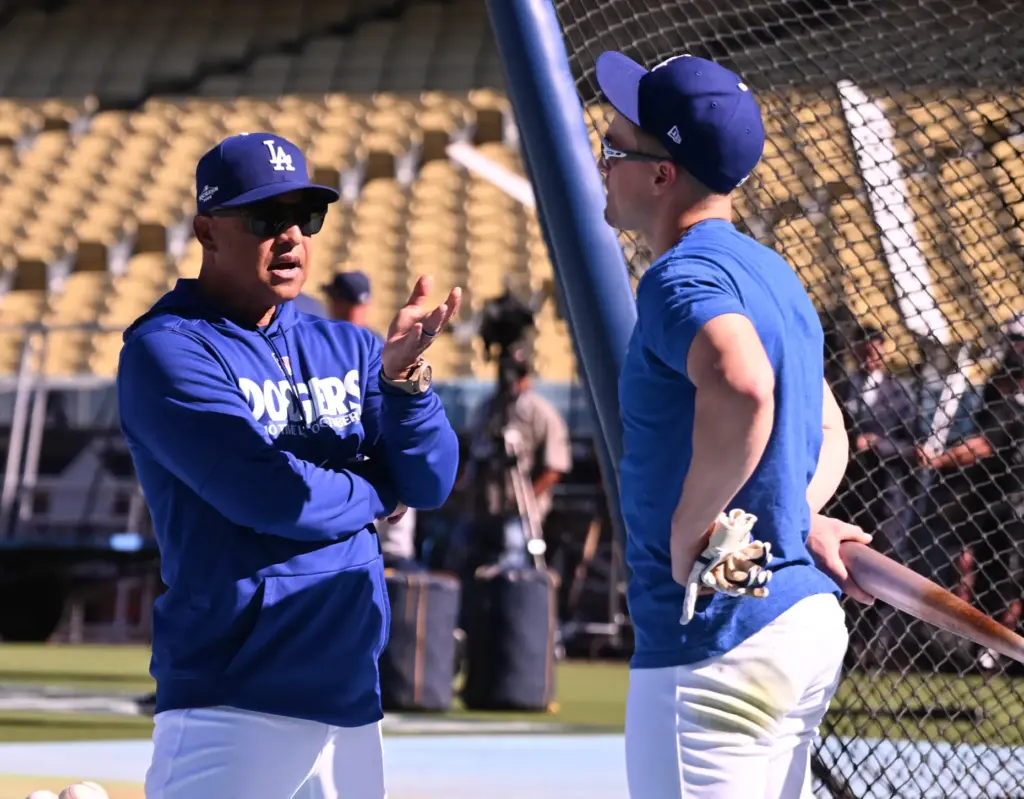Dodgers manager Dave Roberts, left, speaks with utility player Kike...
