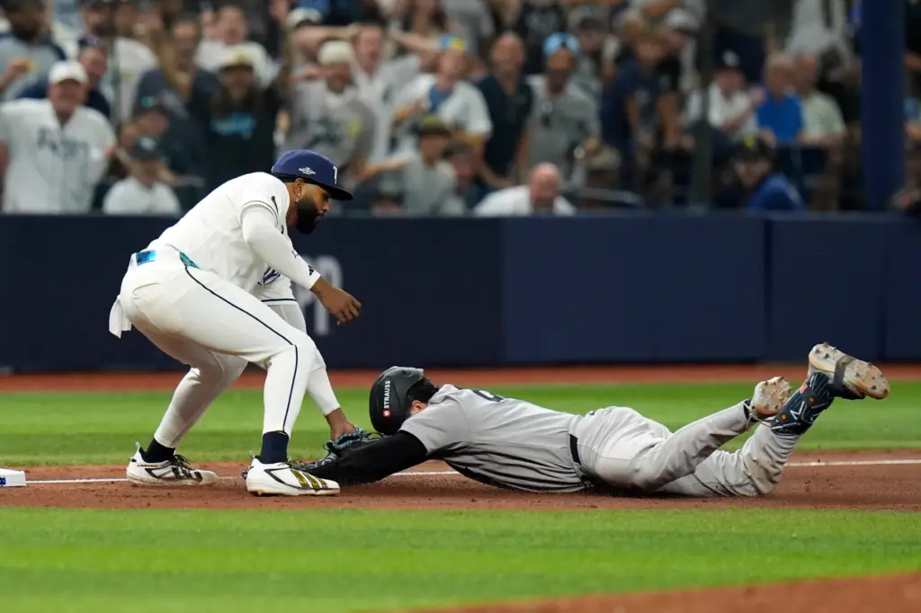 Tampa Bay Rays third baseman Junior Caminero, left, tags out...