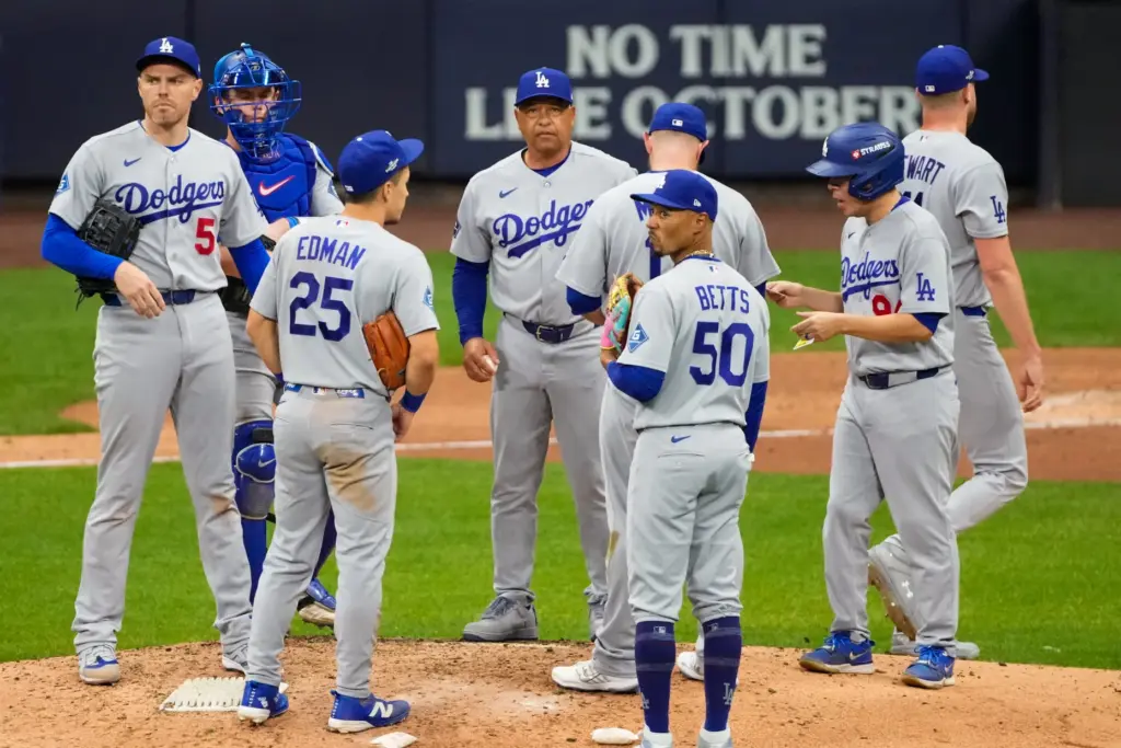 Dodgers manager Dave Roberts, center, stands on the mound with...