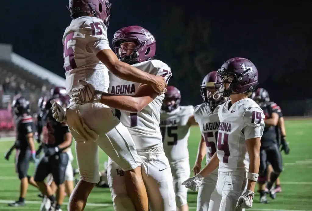 Laguna Beach players celebrate a touchdown by quarterback Braden Hansen...