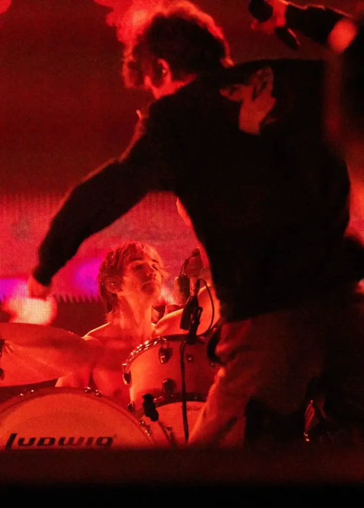 Daniel Fang plays the drums while vocalist Brendan Yates dances...