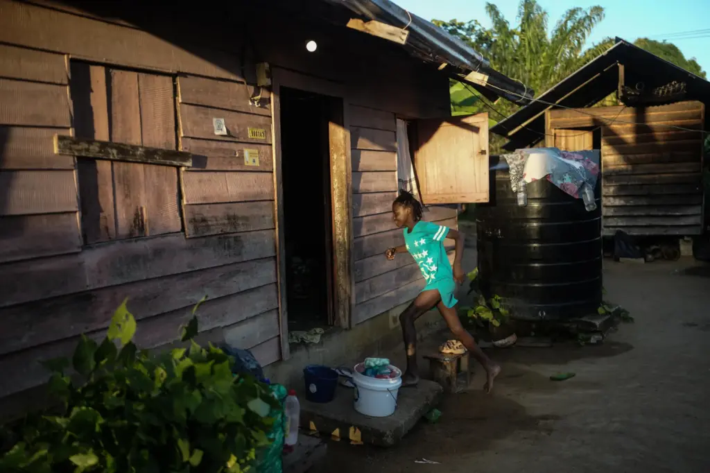 A girl runs to her house in Nieuw Aurora, Suriname,...
