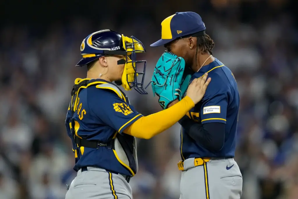 Milwaukee Brewers catcher William Contreras, left, talks with relief pitcher...