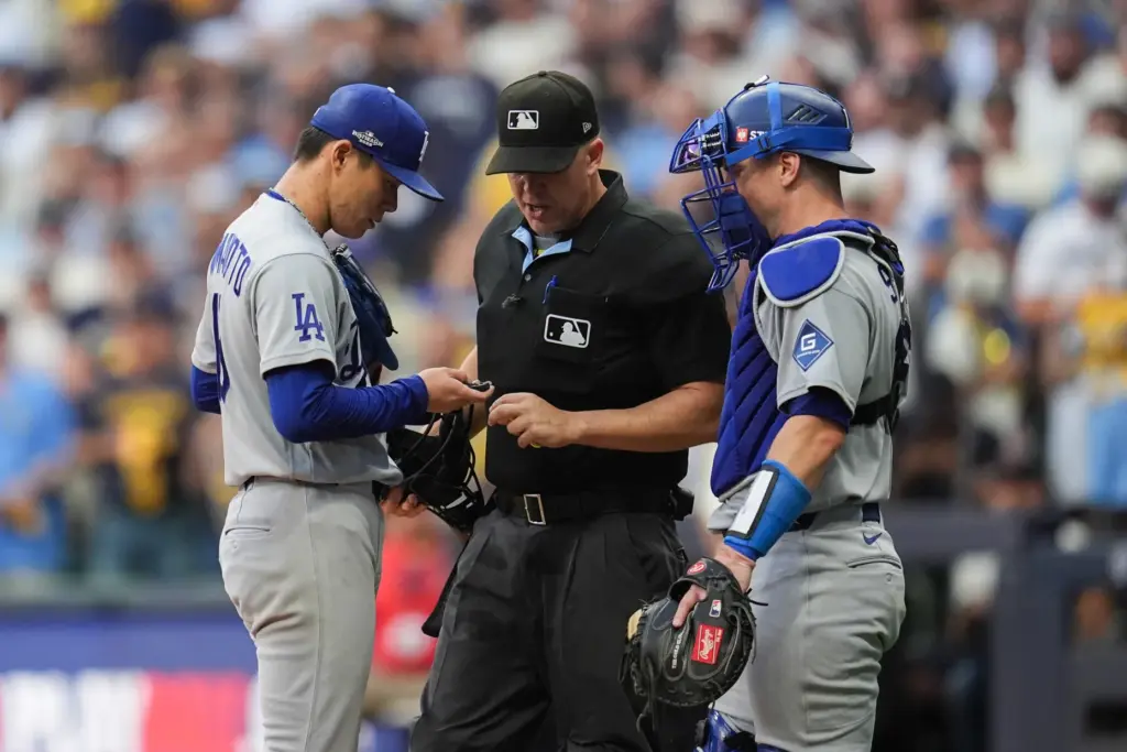 Home plate umpire Chris Segal, center, talks with Dodgers starting...