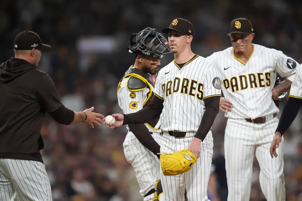 San Diego Padres starting pitcher Walker Buehler, center, is relieved...
