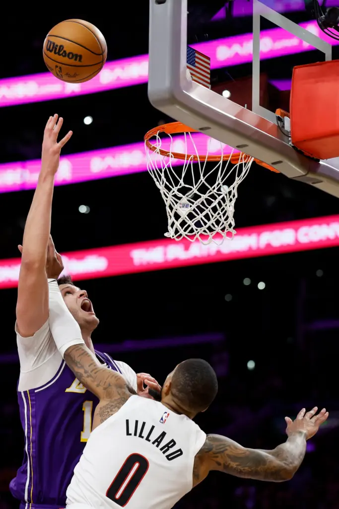 Lakers center Walker Kessler, left, shoots as Portland Trail Blazers...