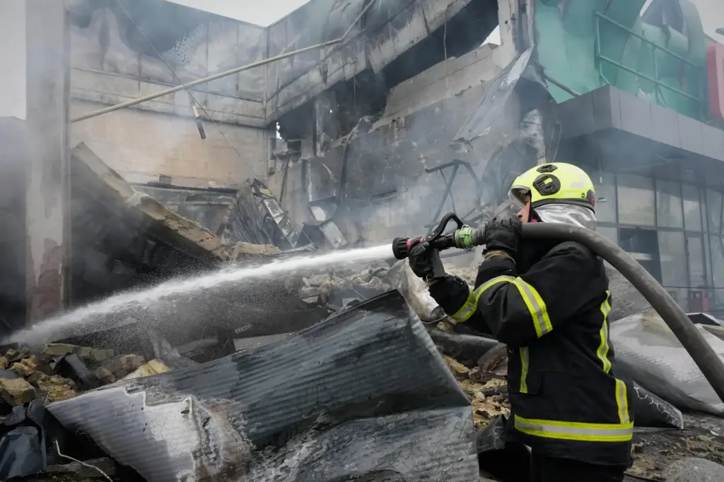 A firefighter tries to extinguish a fire after a Russian...