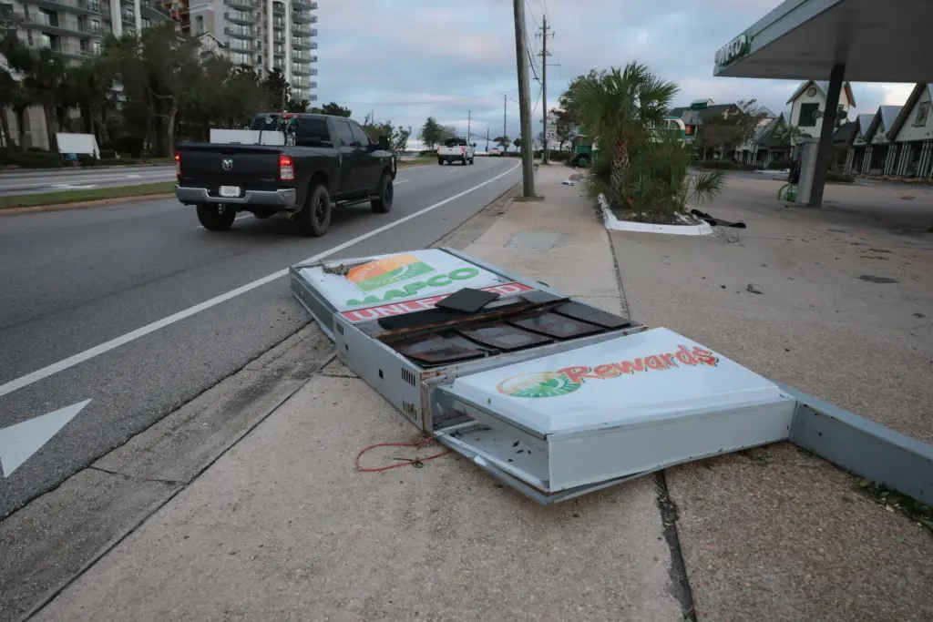 A gas station sign lies on the ground after Hurricane...