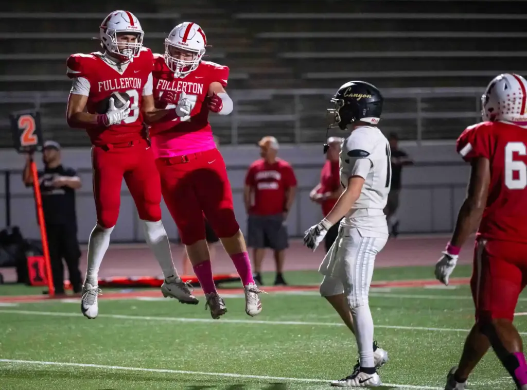 Fullerton players celebrate a touchdown by tight end Isaac Garza...