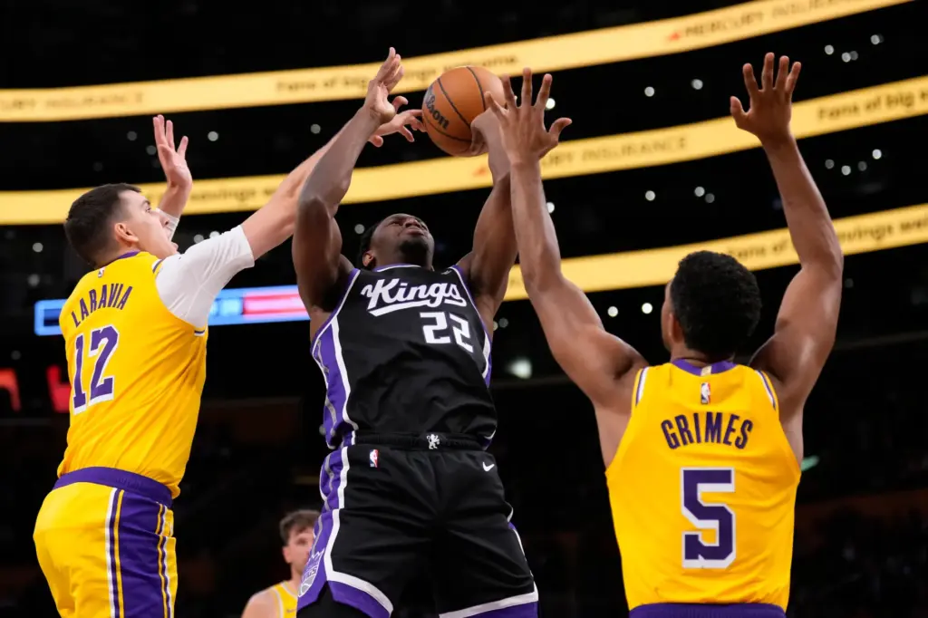 The Sacramento Kings’ Jonathan Mogbo, center, shoots as Lakers forward...