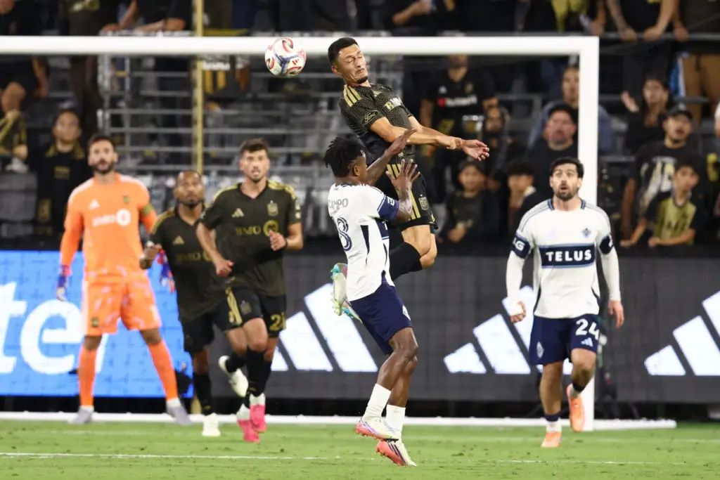 Los Angeles FC midfielder Mark Delgado, top, heads the ball...