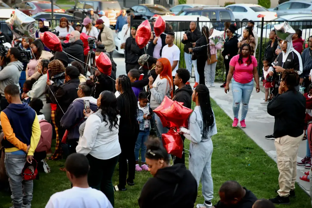 Family, friends and neighbors attend a candlelight vigil in Long...