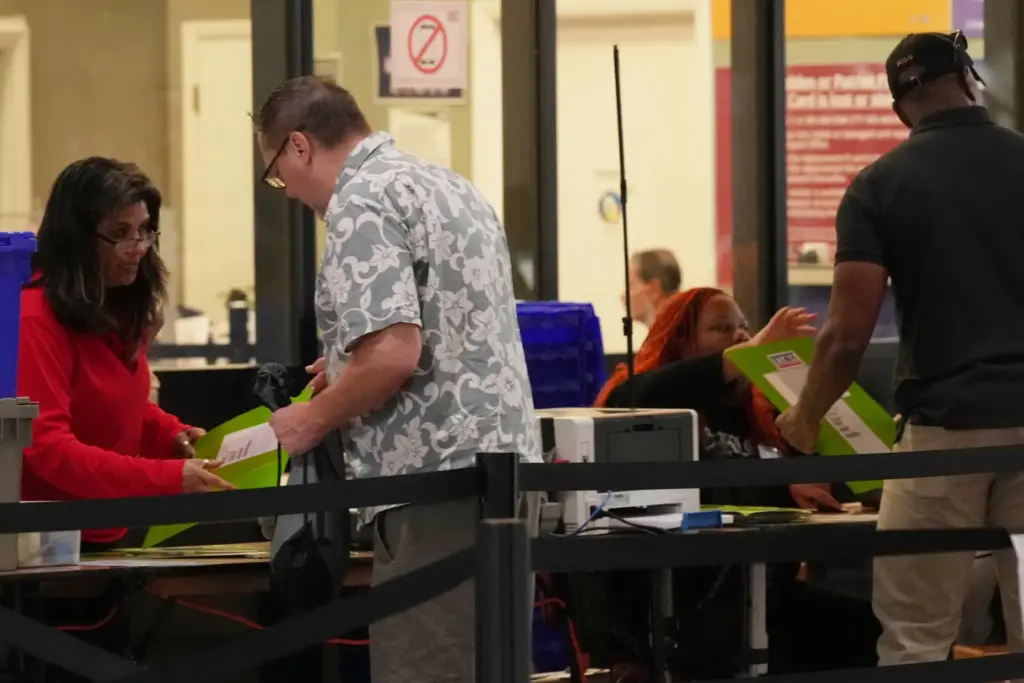Voters get their ballots from Miami-Dade Supervisors of Elections employees during early voting.