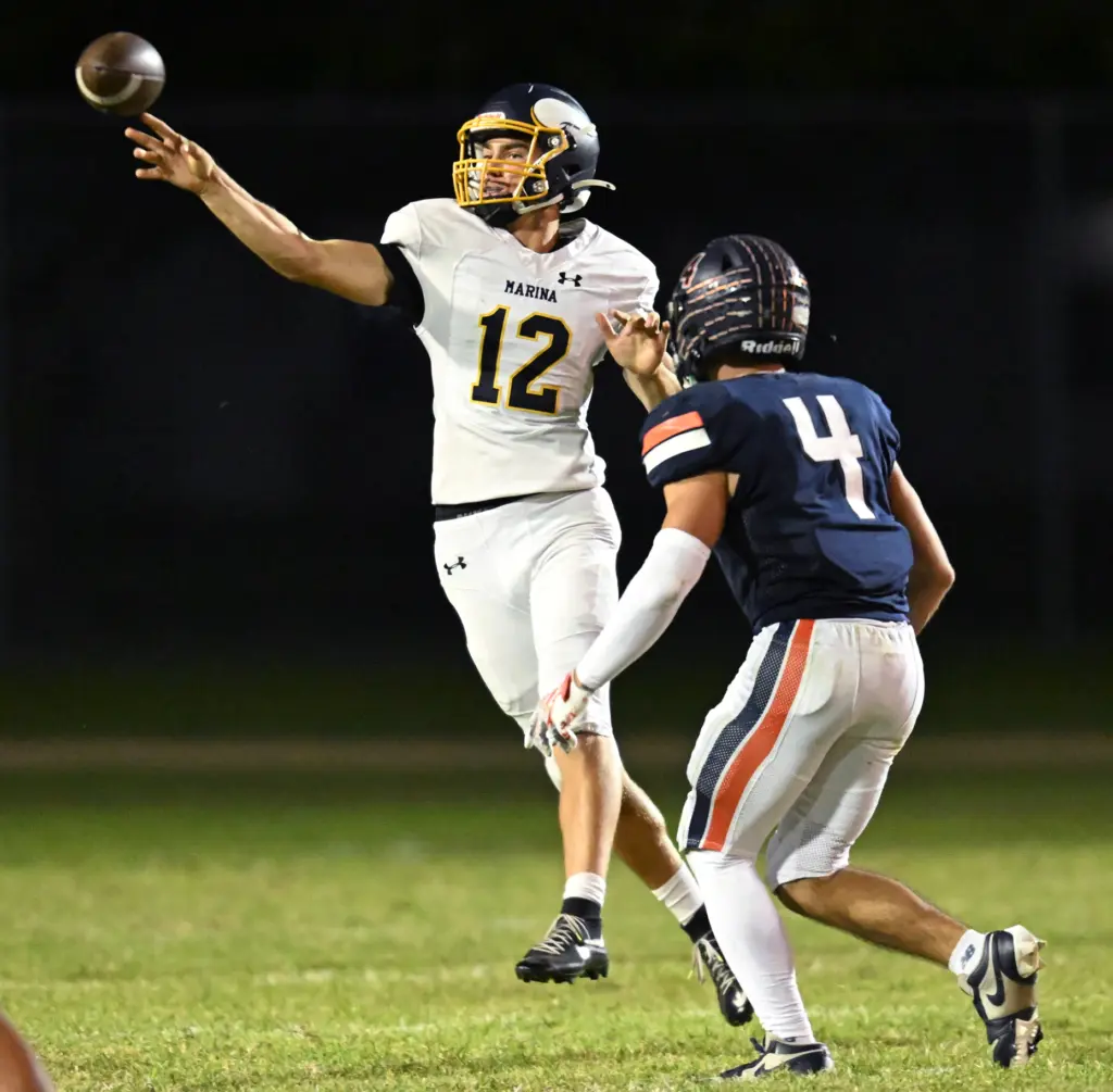Quarterback Maverick Coverick #12 of Marina throws over Alijah Ashcraft...