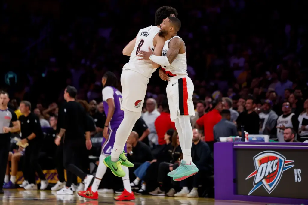 Portland Trail Blazers guard Damian Lillard, right, is greeted by...
