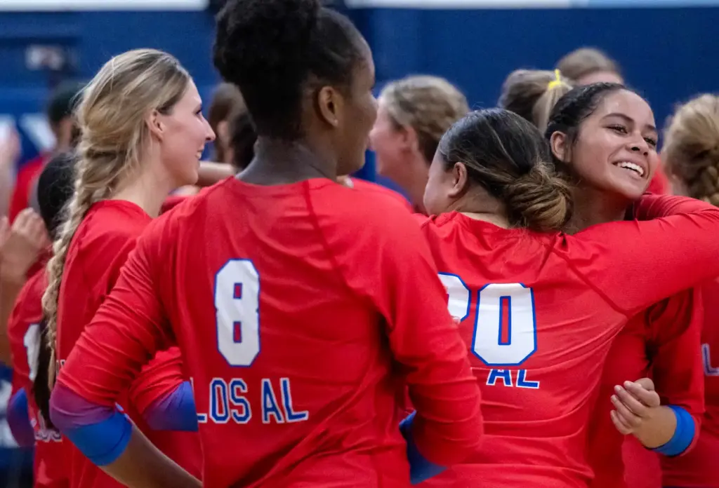Los Alamitos players celebrate their victory in 5 sets over...