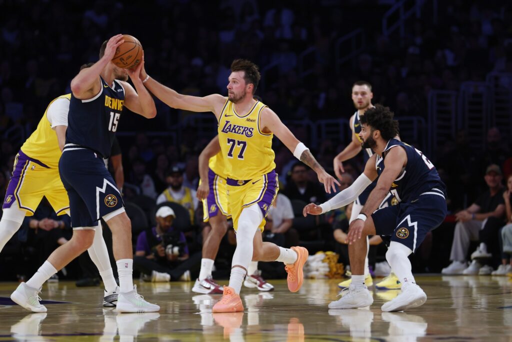 Lakers guard Luka Doncic (77) moves to knock the ball...