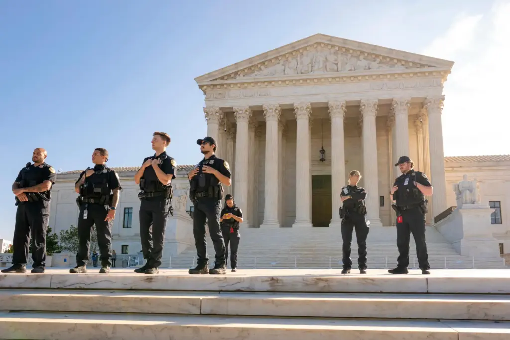 Officers with the Supreme Court Police stand watch as the...