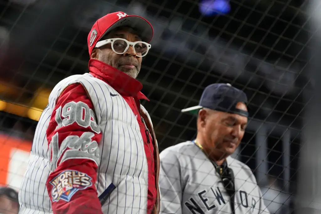 Filmmaker Spike Lee looks on while watching the game between...