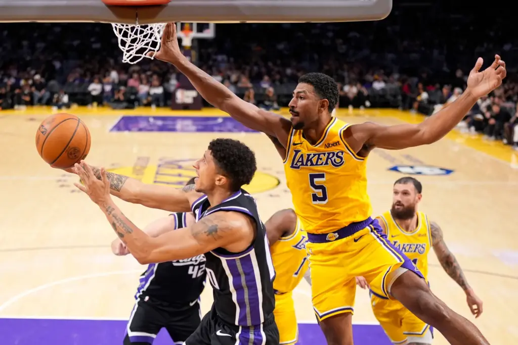 Sacramento Kings guard Nique Clifford, left, shoots as Lakers guard...