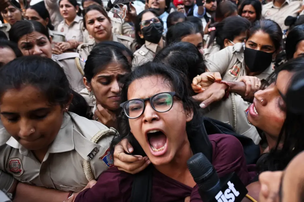 Prominent student leader Neha Bora, center, shouts slogans as she...