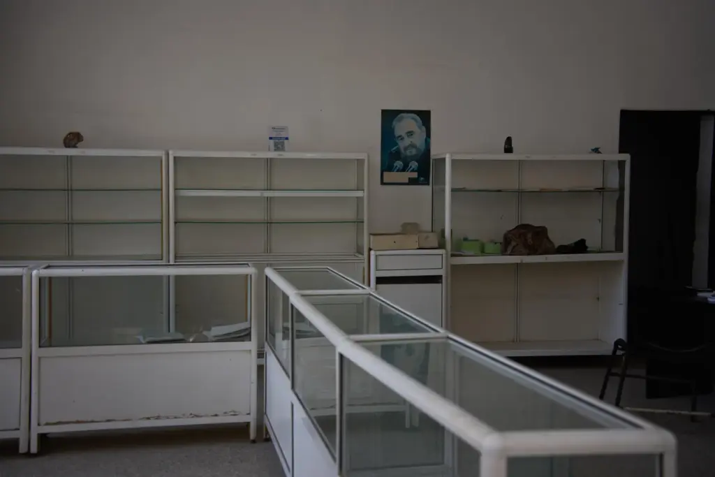 A poster of Fidel Castro hangs on the wall, flanked...