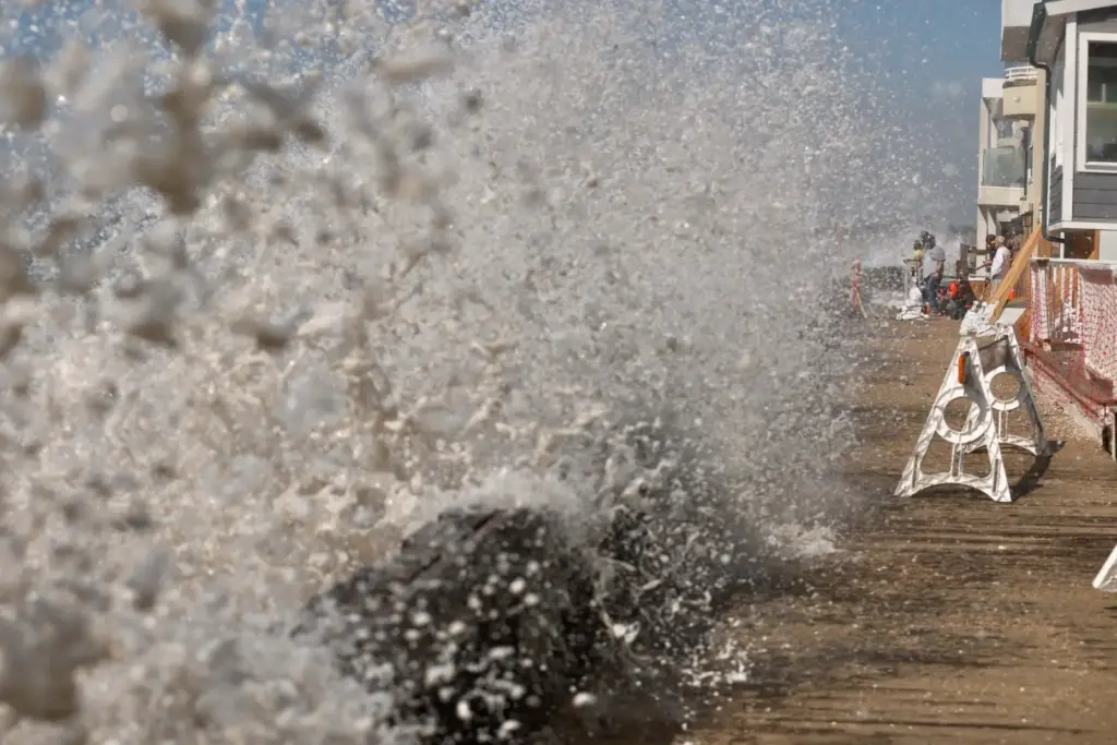 Waves crash into the Peninsula in Long Beach on Friday,...