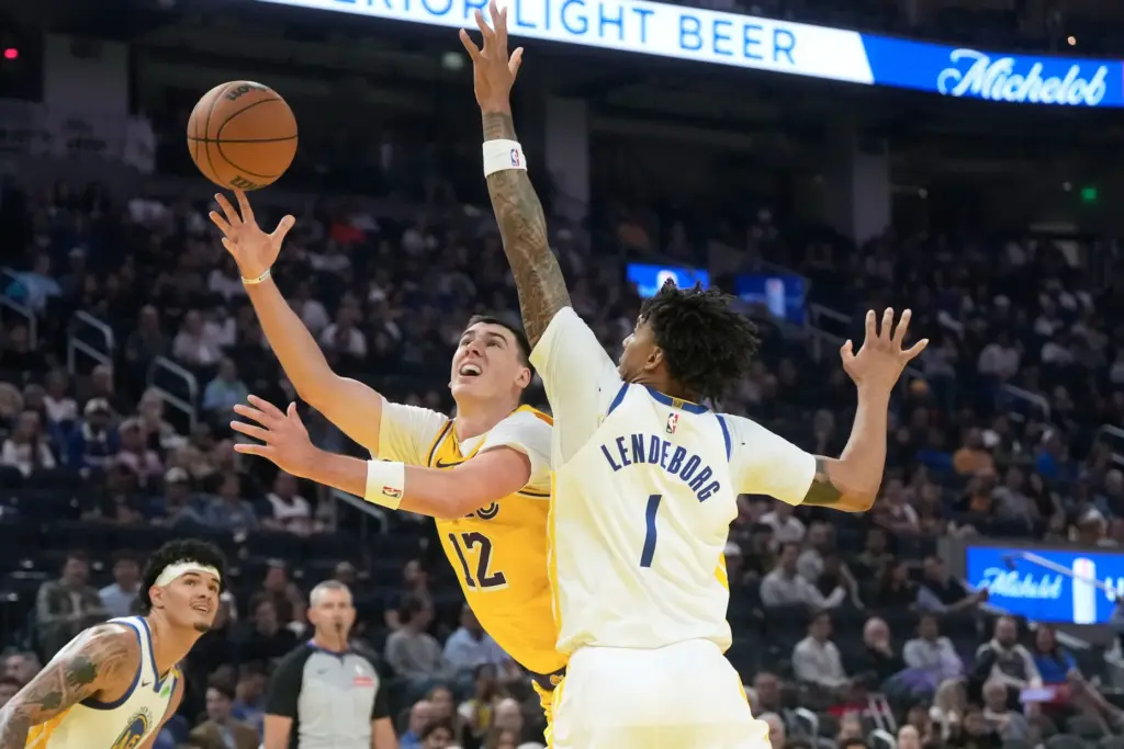 Lakers forward Jake LaRavia, left, shoots as Golden State Warriors...