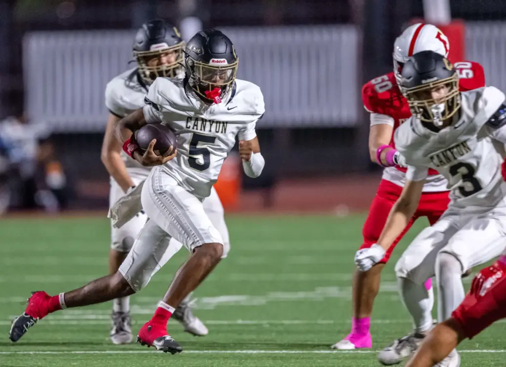 Canyon quarterback Kayden Phillips (5) carries the ball on a...