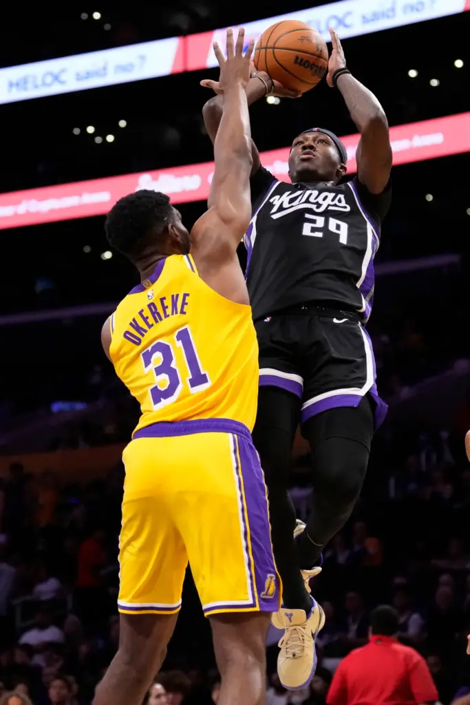 Sacramento Kings guard/forward Daeqwon Plowden, right, shoots as Lakers forward...